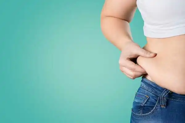 Image of woman pinching her love handles to show weight gain Staffordshire